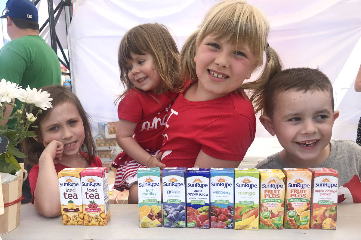From left: Chloe, Aubrey and Ryley with friend Nolan. At their juice stand this summer, the girls raised $814 for the Centre for Child Development. (Photo: Amy Reid)