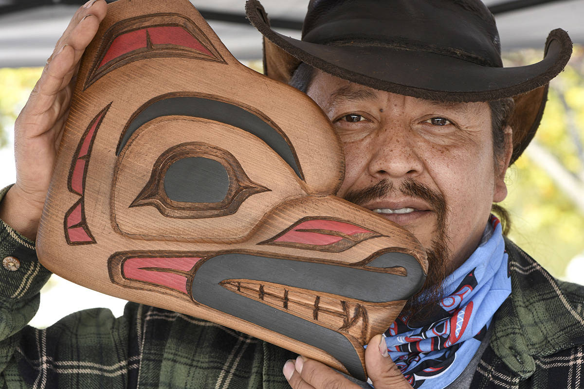 Artist Archie Andrew shows off one of his carved masks. Don Denton photography