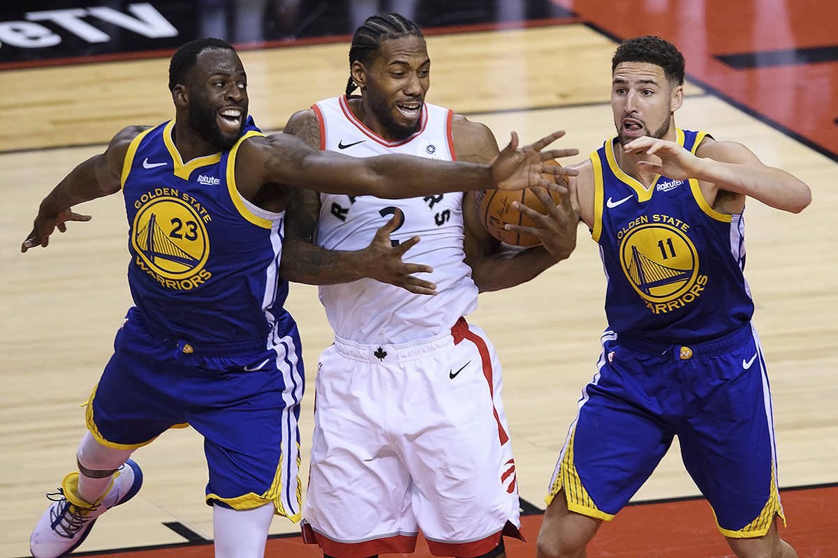 Toronto Raptors forward Kawhi Leonard (2) gets double covered by Golden State Warriors guard Klay Thompson (11) and Warriors forward Draymond Green (23) during second half of Game 2 NBA Finals basketball action in Toronto on Sunday, June 2, 2019. THE CANADIAN PRESS/Nathan Denette