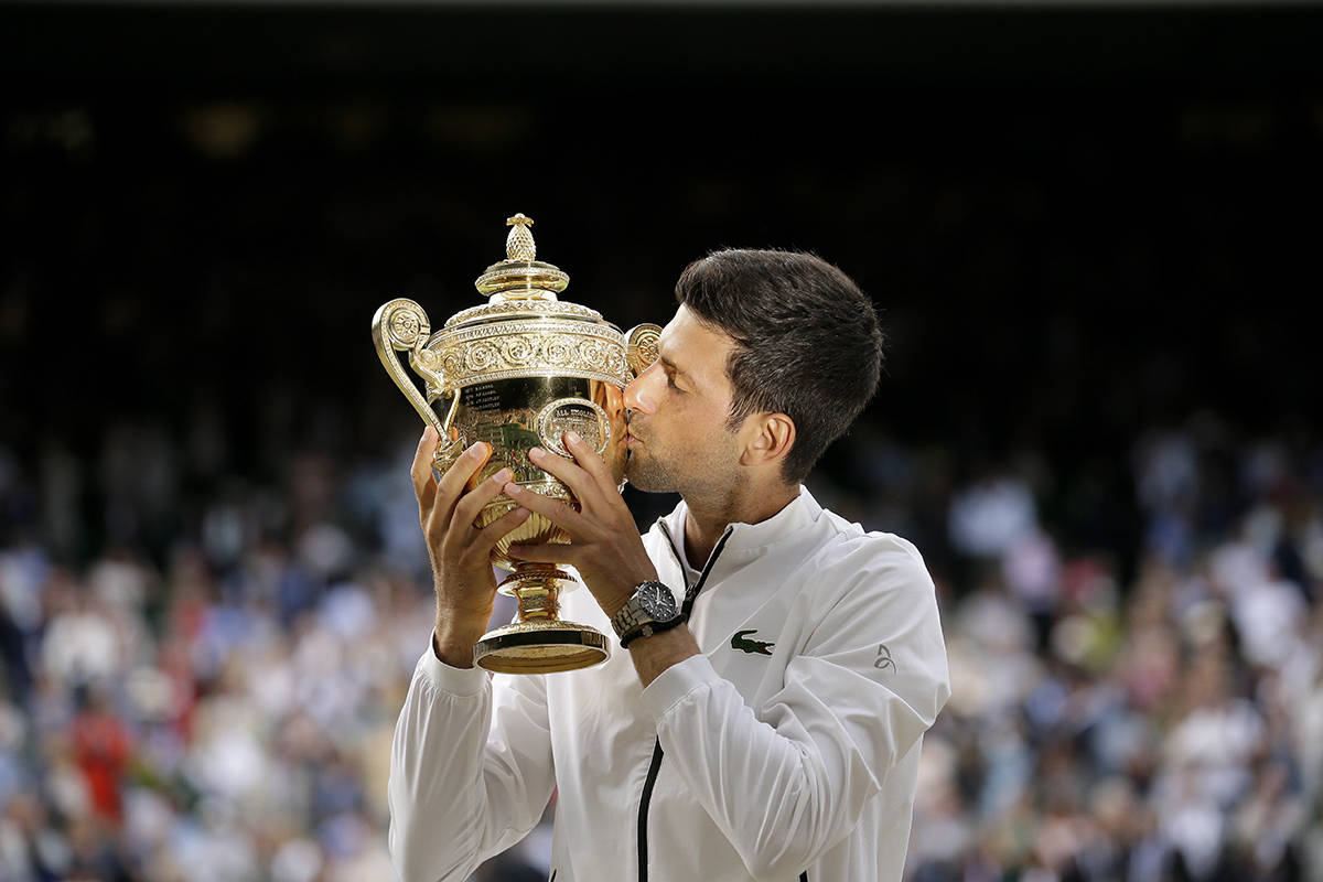 Serbia’s Novak Djokovic kisses the trophy after defeating Switzerland’s Roger Federer in the men’s singles final match of the Wimbledon Tennis Championships in London, Sunday, July 14, 2019. (AP Photo/Tim Ireland)
