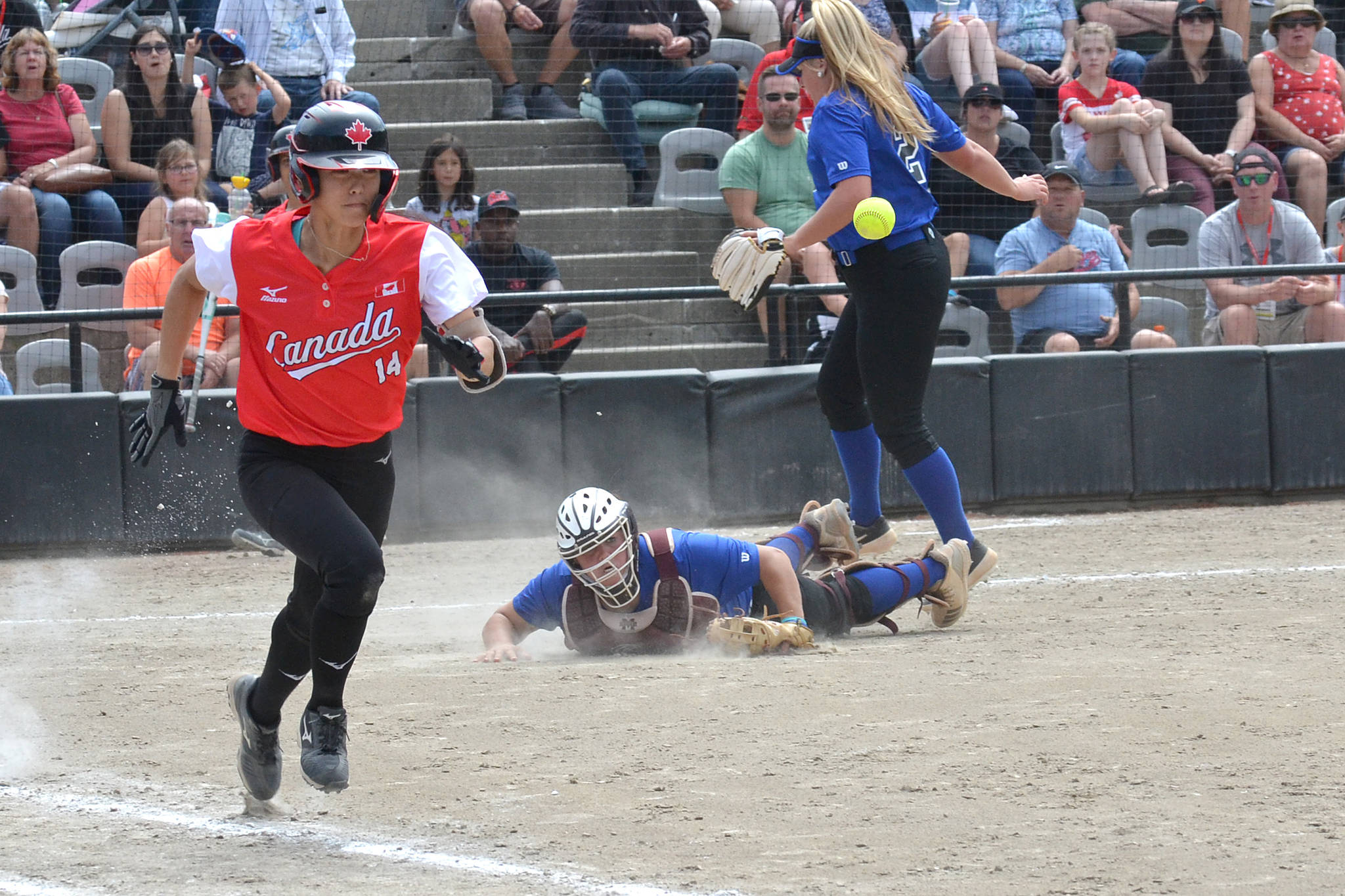 Triple Crown Colorado catcher Mia Davidson loses her balance and falls after scooping up a ball and quickly throwing to first base, as Team Canada shortstop Janet Leung tries to outrun the throw during a Canada Cup round-robin game Friday afternoon. (Nick Greenizan photo)