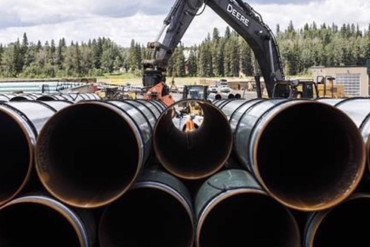 Pipe for the Trans Mountain pipeline is unloaded in Edson, Alta. (THE CANADIAN PRESS/Jason Franson)