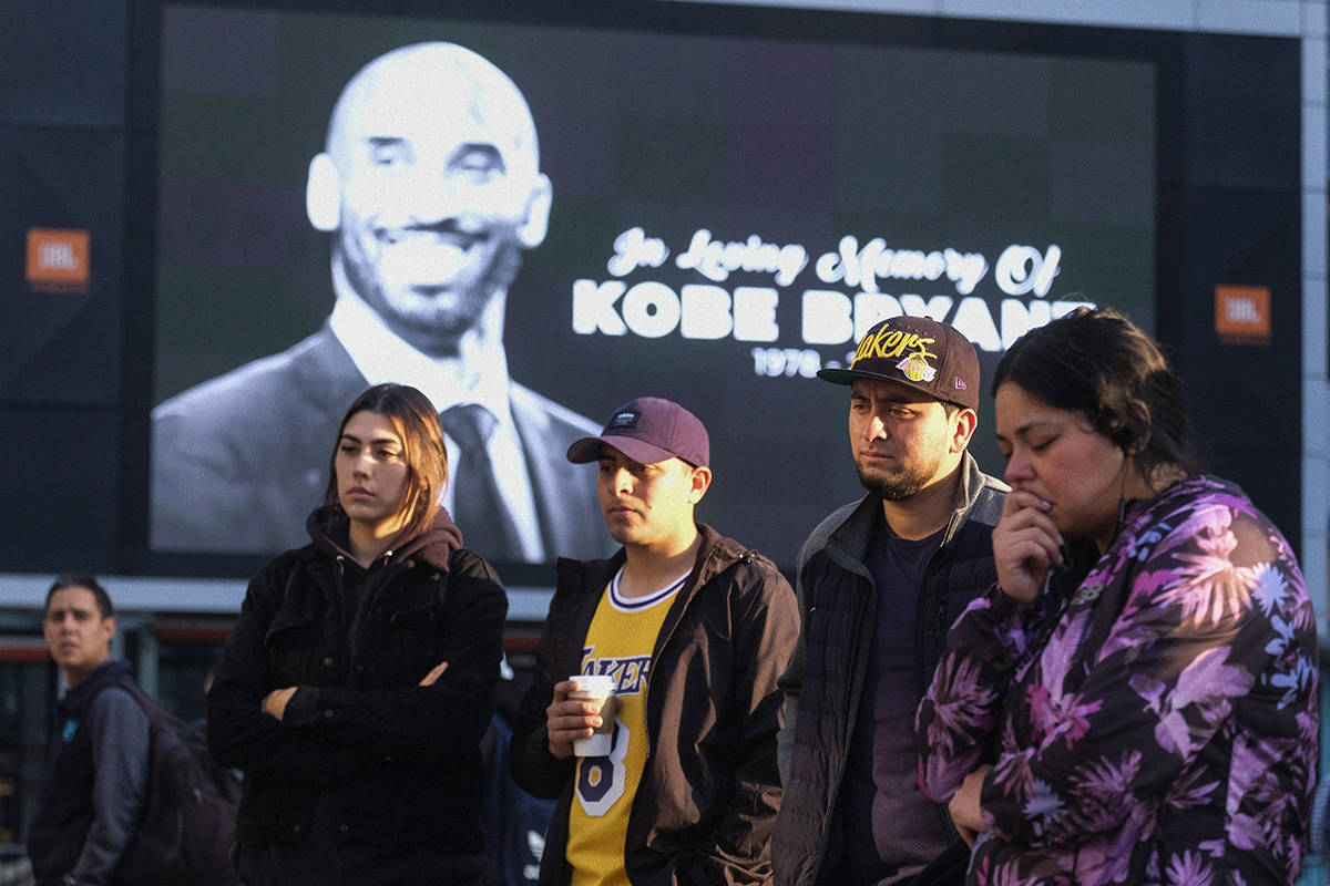 Fans pay their respect at a memorial for Kobe Bryant near Staples Center Monday, Jan. 27, 2020, in Los Angeles. Bryant, the 18-time NBA All-Star who won five championships and became one of the greatest basketball players of his generation during a 20-year career with the Los Angeles Lakers, died in a helicopter crash Sunday. (AP Photo/Ringo H.W. Chiu)