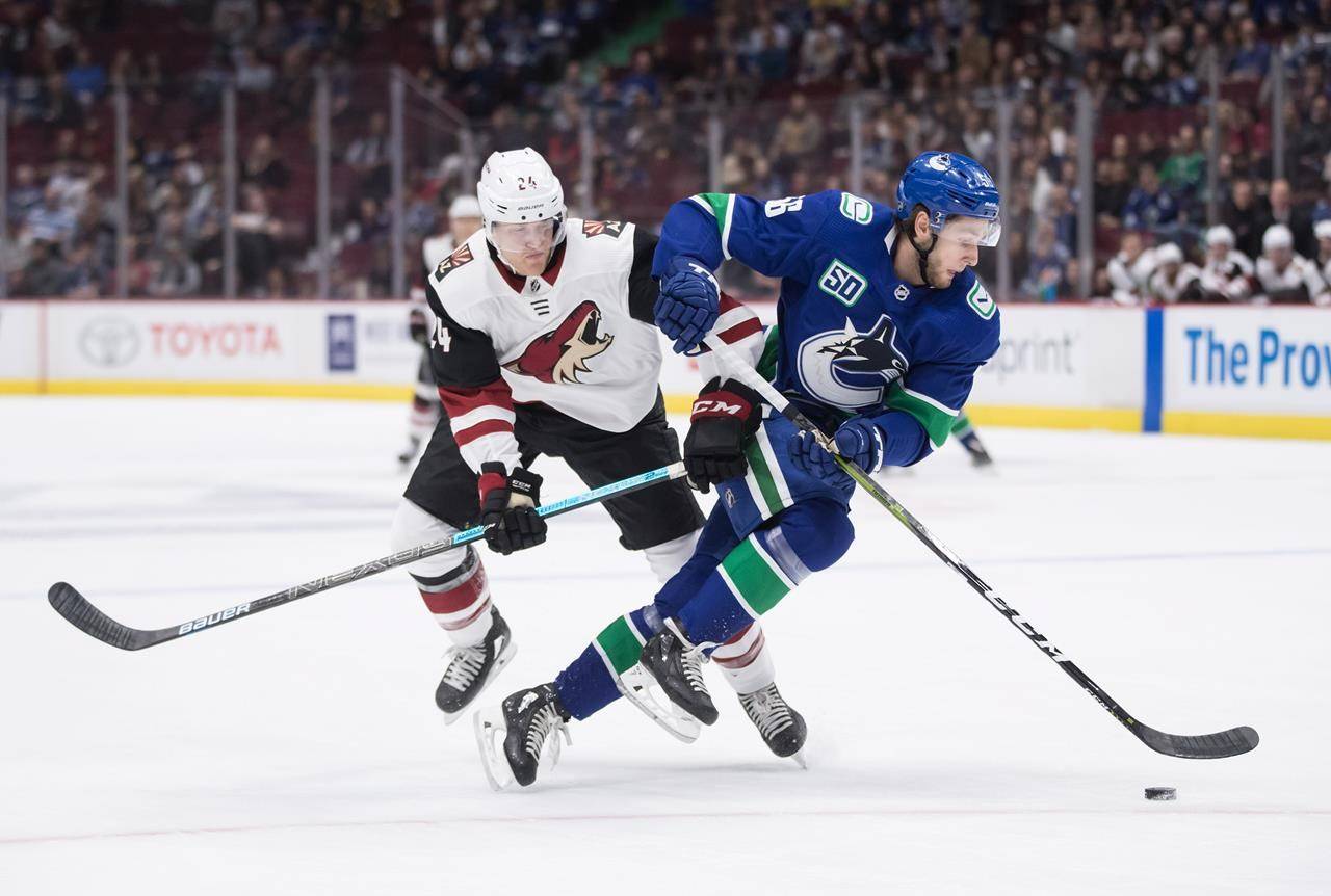 Arizona Coyotes right wing Hudson Fasching, left, and Vancouver Canucks defenceman Guillaume Brisebois collide during the first period of a pre-season NHL hockey game in Vancouver on September 26, 2019. The Vancouver Canucks have recalled defencemen Guillaume Brisebois and Jalen Chatfield from Utica of the American Hockey League under emergency conditions. The Canucks also announced forward Justin Bailey has been reassigned to Utica. (THE CANADIAN PRESS/Darryl Dyck)