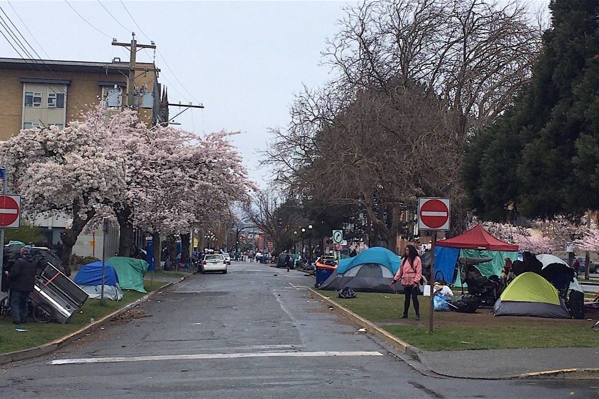 Tents stretch for blocks on Pandora Street in downtown Victoria March 26, with handouts of food, clothing and needles continuing outside a drop-in centre that has been forced to close due to COVID-19 rules. (Tom Fletcher/Black Press)