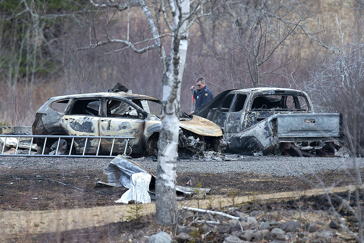 An RCMP investigator inspects vehicles destroyed by fire at the residence of Alanna Jenkins and Sean McLean, both corrections officers, in Wentworth Centre, N.S. on Monday, April 20, 2020. A neighbour, Tom Bagley, was also killed on the property. Police say at least 19 people are dead, including RCMP Const. Heidi Stevenson, after a man, driving a restored police car, went on a murder spree in several Nova Scotia communities. The alleged killer, 51, was shot and killed by police. THE CANADIAN PRESS/Andrew Vaughan