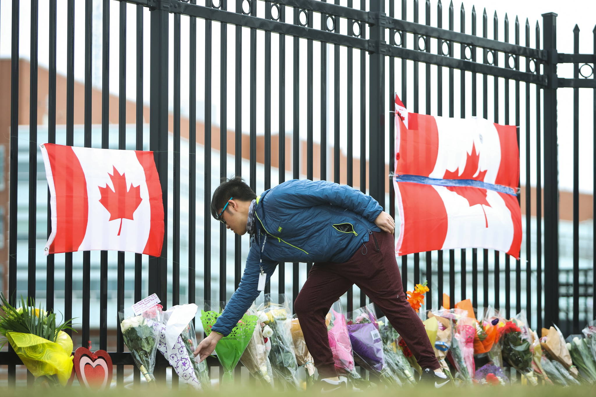A person leaves flowers at a make-shift memorial dedicated to Constable Heidi Stevenson at RCMP headquarters in Dartmouth, Nova Scotia, Monday, April 20, 2020. Investigators say a killer’s use of a mock police cruiser and an RCMP uniform almost identical to the real thing helped him escape detection as he travelled between 16 crime scenes in a rampage that has left at least 19 dead in Nova Scotia. THE CANADIAN PRESS/Riley Smith