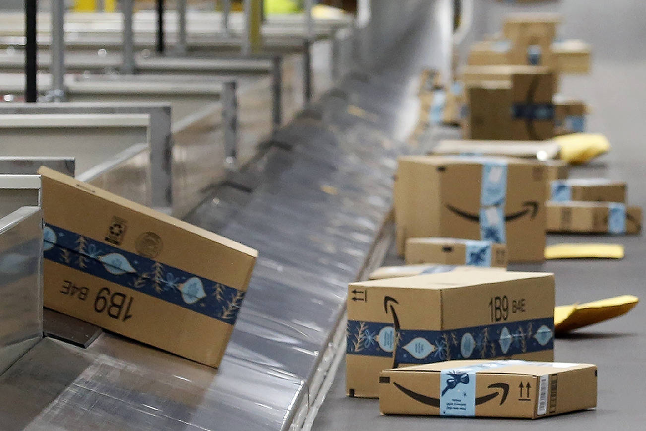 FILE - In this Dec. 17, 2019, file photo, Amazon packages move along a conveyor at an Amazon warehouse facility in Goodyear, Ariz. Amazon will report quarterly earnings on Thursday, APril 30, 2020, providing a first glimpse into its financial performance during the pandemic. (AP Photo/Ross D. Franklin, File)
