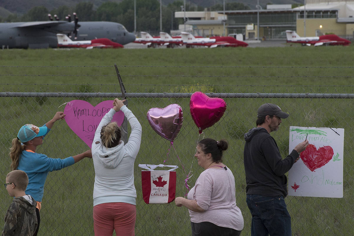 Canadian Forces Snowbirds planes are seen in the background as people place hearts and signs on the fence surrounding the airport in Kamloops, B.C., Sunday, May 17, 2020. One member of the Canadian Armed Forces has died and another is injured after a Snowbird plane crashed in a residential area of Kamloops, B.C., on Sunday while on a cross-country tour meant to impart hope during the COVID-19 pandemic. THE CANADIAN PRESS/Jonathan Hayward