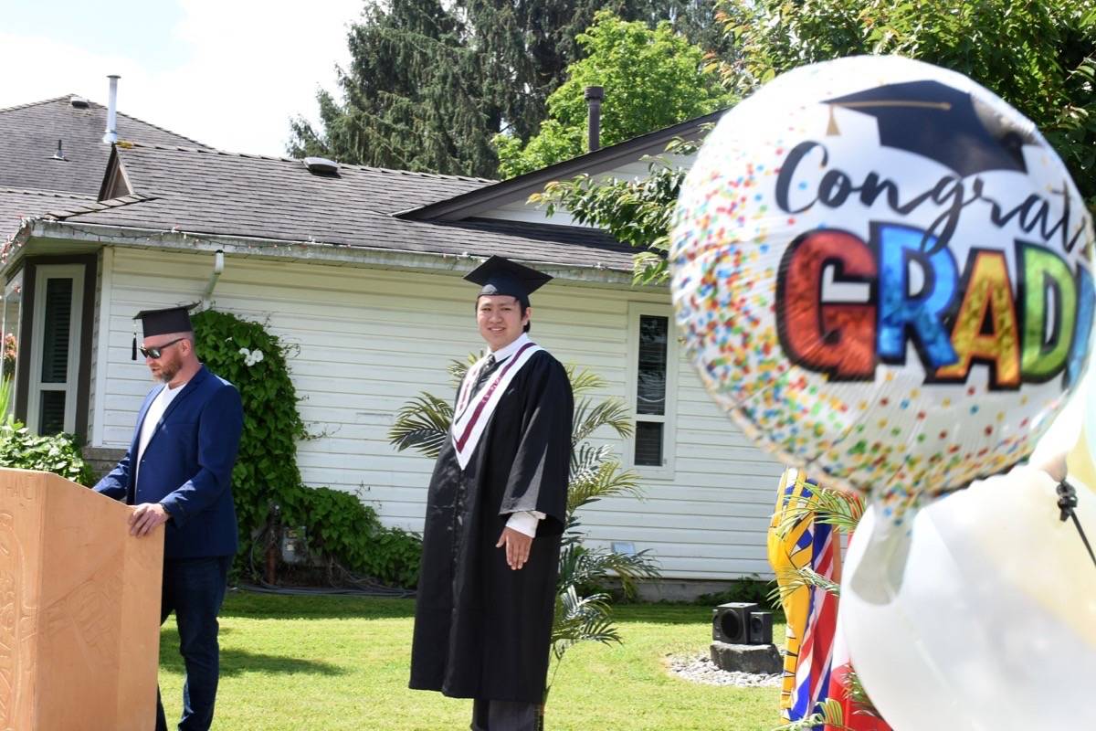 Ryan Neufeld, a support teacher at Thomas Haney Secondary School, gives the convocation speech as Masato Wong looks on. (Colleen Flanagan-THE NEWS)