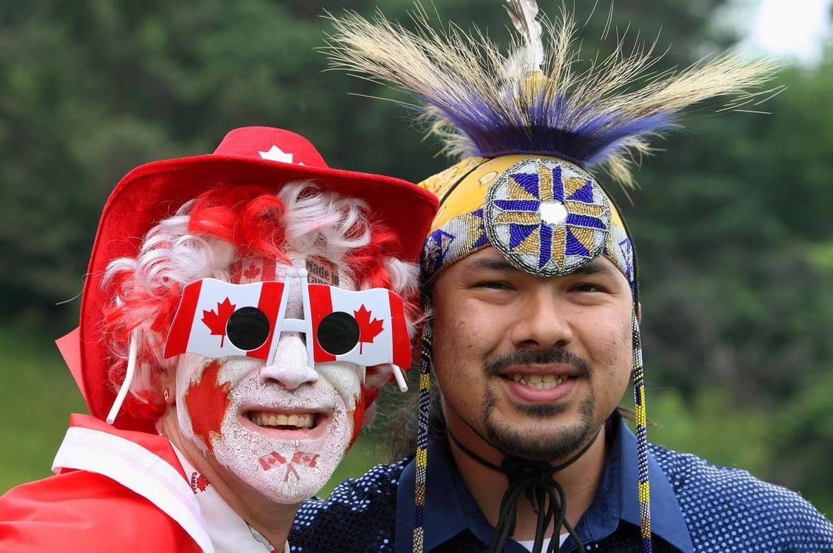Greg Sturm (left) poses with native dancer Barry Albert during a Canada Day celebration, Monday, July 1, 2013 in London, Ont. Indigenous communities and leaders are sharing their Canada Day frustrations. THE CANADIAN PRESS//Dave Chidley