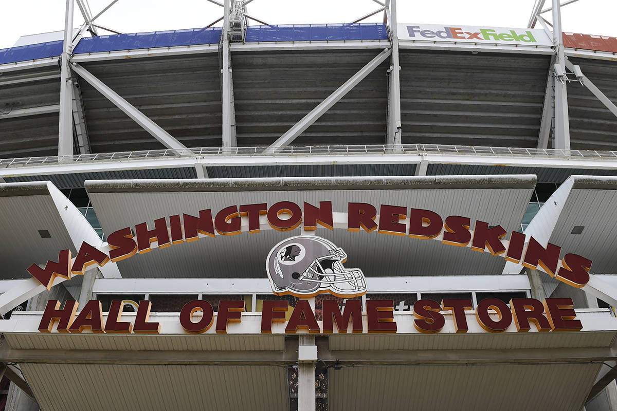 Signs for the Washington Redskins are displayed outside FedEx Field in Landover, Md., Monday, July 13, 2020. The Washington NFL franchise announced Monday that it will drop the “Redskins” name and Indian head logo immediately, bowing to decades of criticism that they are offensive to Native Americans. (AP Photo/Susan Walsh)