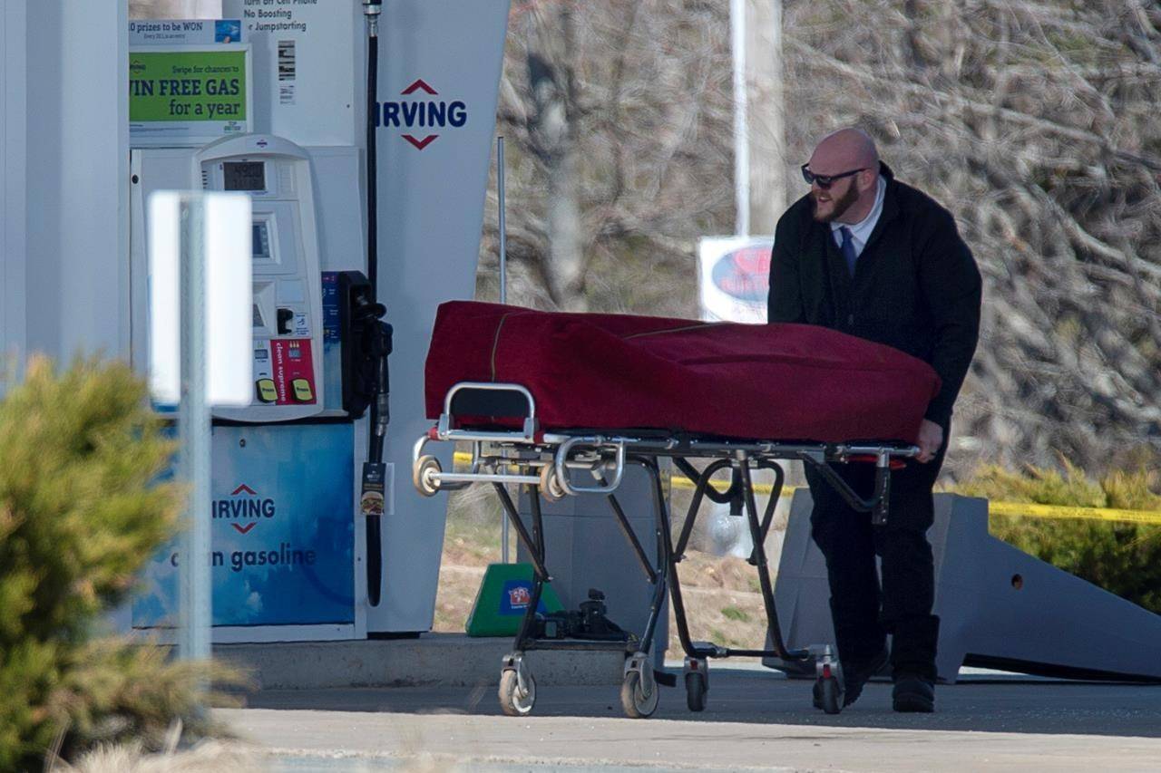A worker with the medical examiner’s office removes a body from a gas bar in Enfield, N.S. on Sunday, April 19, 2020. Over three dozen Canadian senators are calling for an inquiry into the mass shootings that left 22 people dead in Nova Scotia in April. THE CANADIAN PRESS/Andrew Vaughan