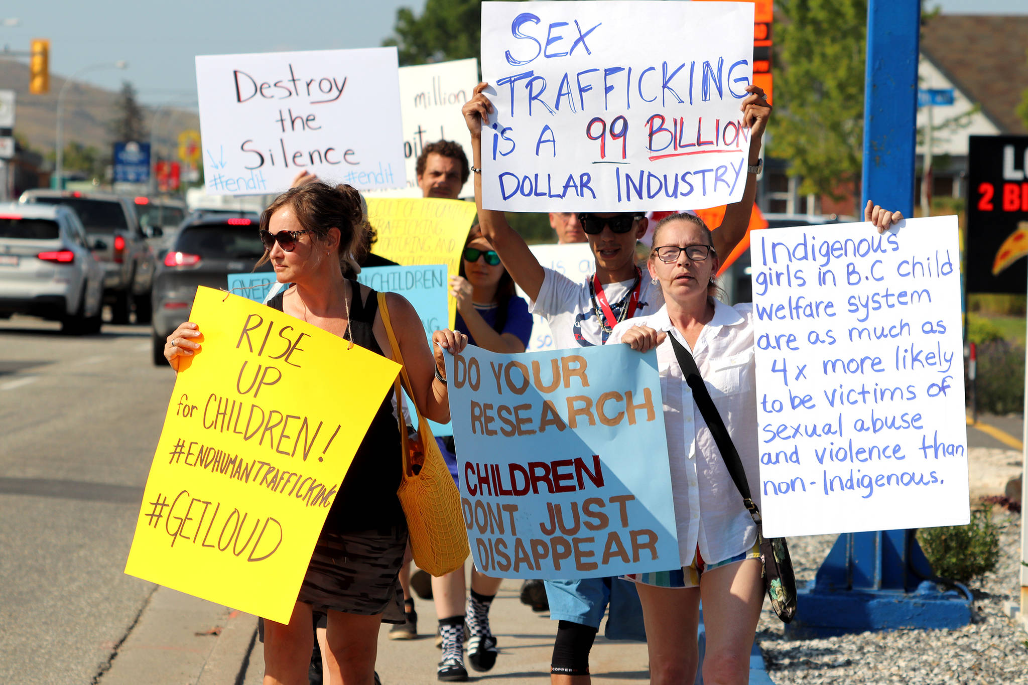 Heather Leggett (right) joined close to 20 people to march along 32nd Street in the intense heat Thursday, July 30 to raise awareness around sex trafficking. (Jennifer Smith - Morning Star)