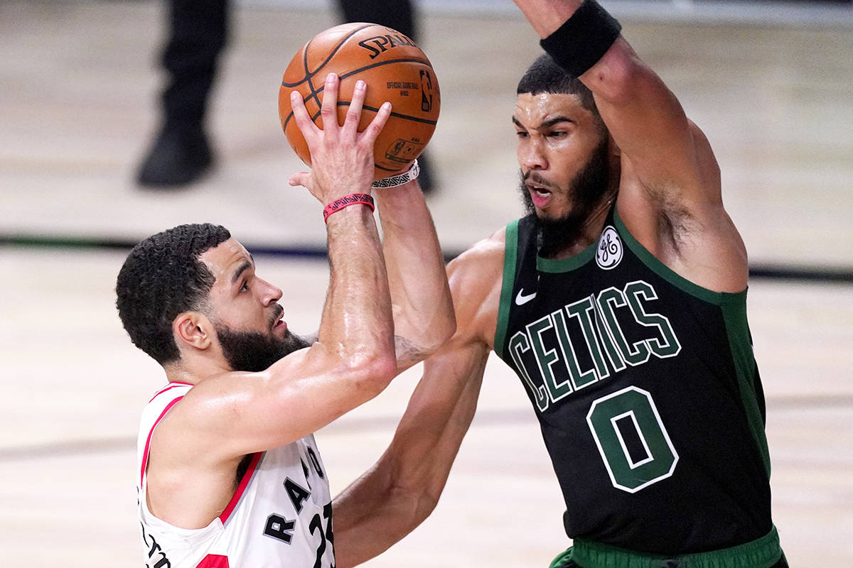 Toronto Raptors’ Fred VanVleet, left, goes up for a shot against Boston Celtics’ Jayson Tatum during the first half of an NBA conference semifinal playoff basketball game Friday, Sept. 11, 2020, in Lake Buena Vista, Fla. (AP Photo/Mark J. Terrill)