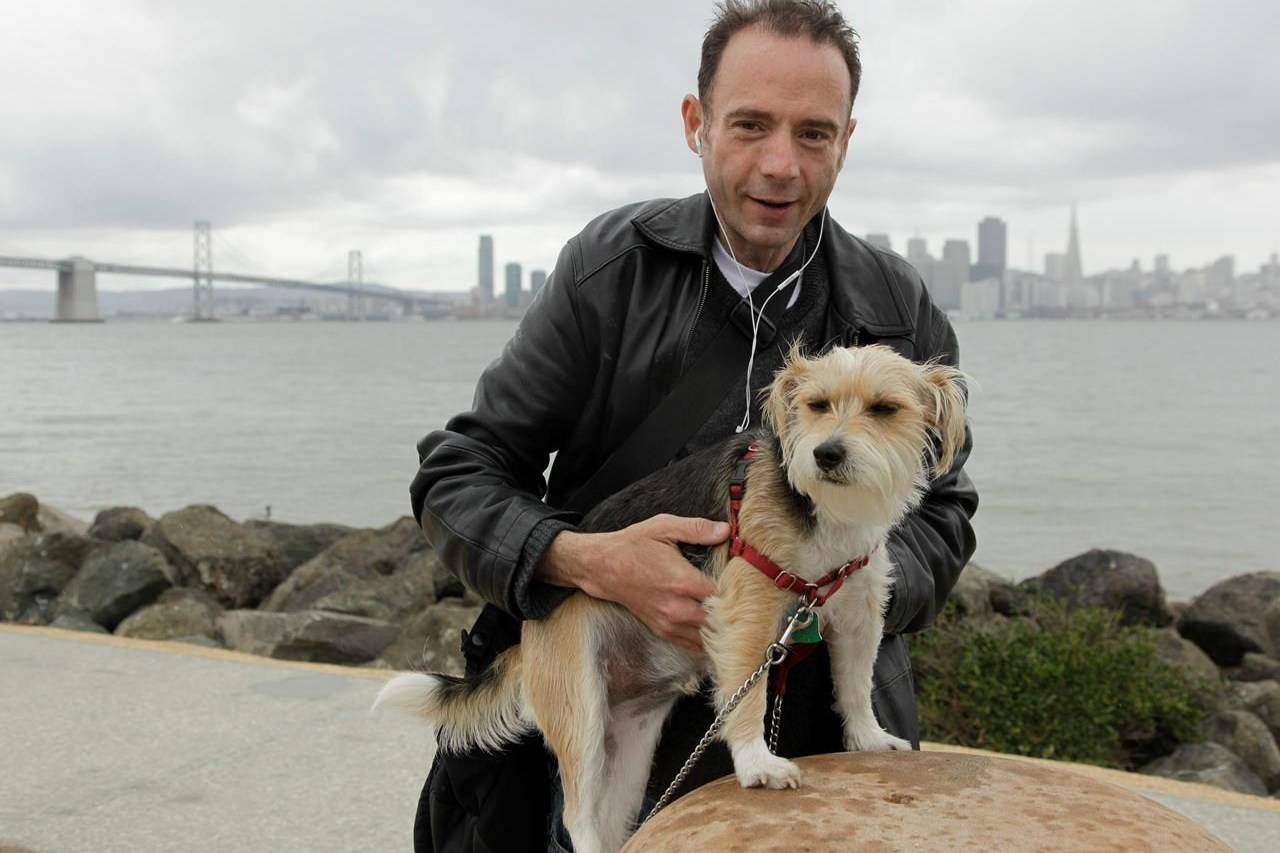 FILE - This May 16, 2011 photo shows Timothy Ray Brown with his dog, Jack, on Treasure Island in San Francisco. Brown, who was known for years as the Berlin patient, had a transplant in Germany from a donor with natural resistance to the AIDS virus. It was thought to have cured Brown’s leukemia and HIV. But in an interview Thursday, Sept. 24, 2020, Brown said his cancer returned last year and has spread widely. His case has inspired scientists to seek more practical ways to try to cure the disease. (AP Photo/Eric Risberg)