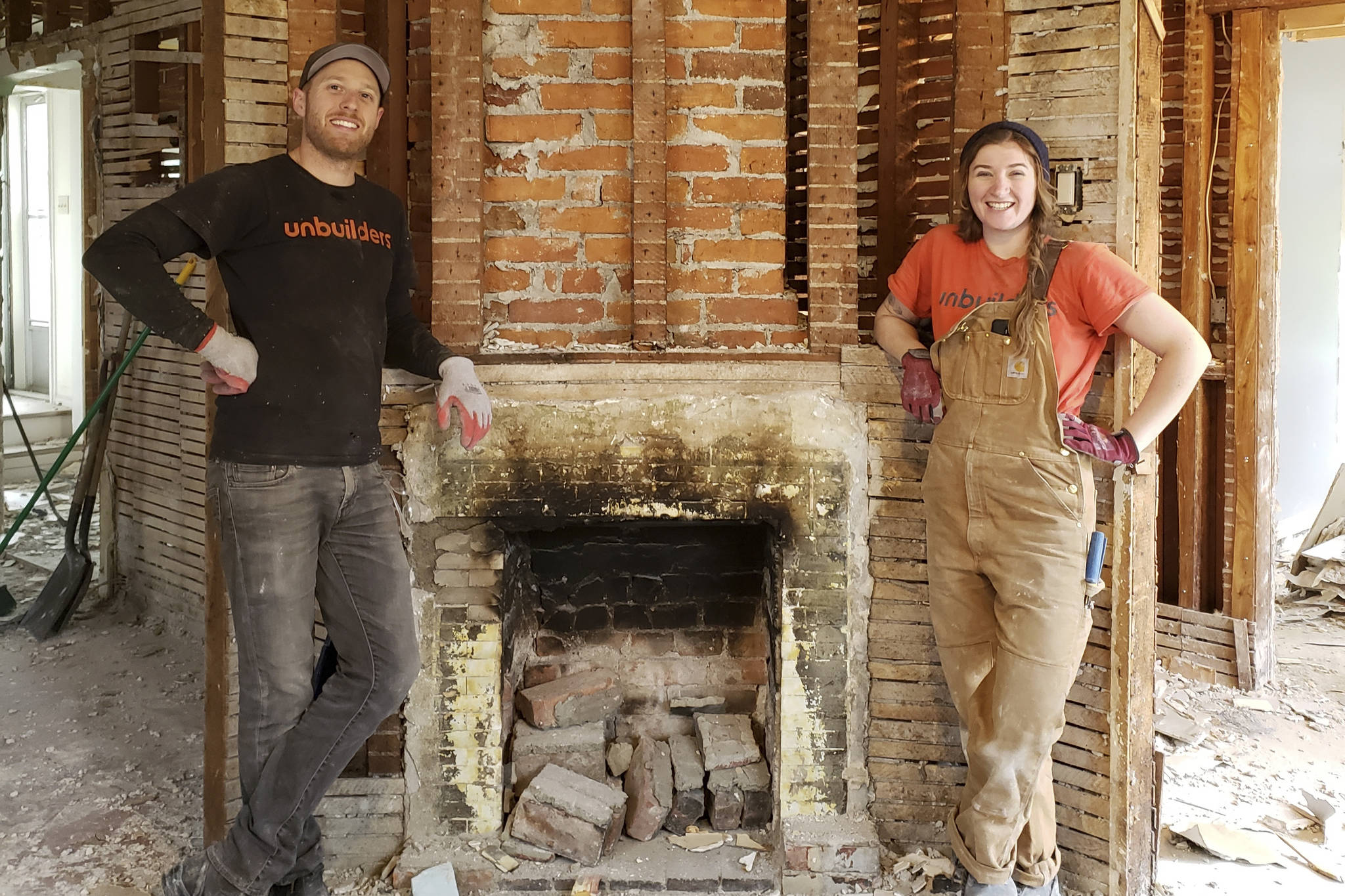 Unbuilders owner Adam Corneil with employee Erin Watkins in front of a deconstructed hearth. Unbuilders crews carefully deconstruct old homes to rescue as many reusable materials as possible, including old-growth timber. (Unbuilders photo)