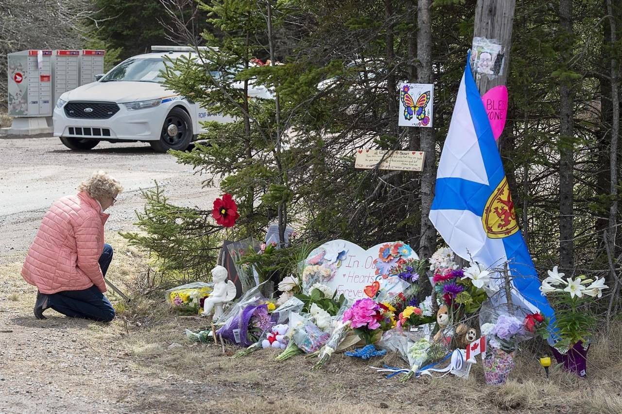 A woman pays her respects to victims of a mass shooting at a roadblock in Portapique, N.S. on Wednesday, April 22, 2020. THE CANADIAN PRESS/Andrew Vaughan