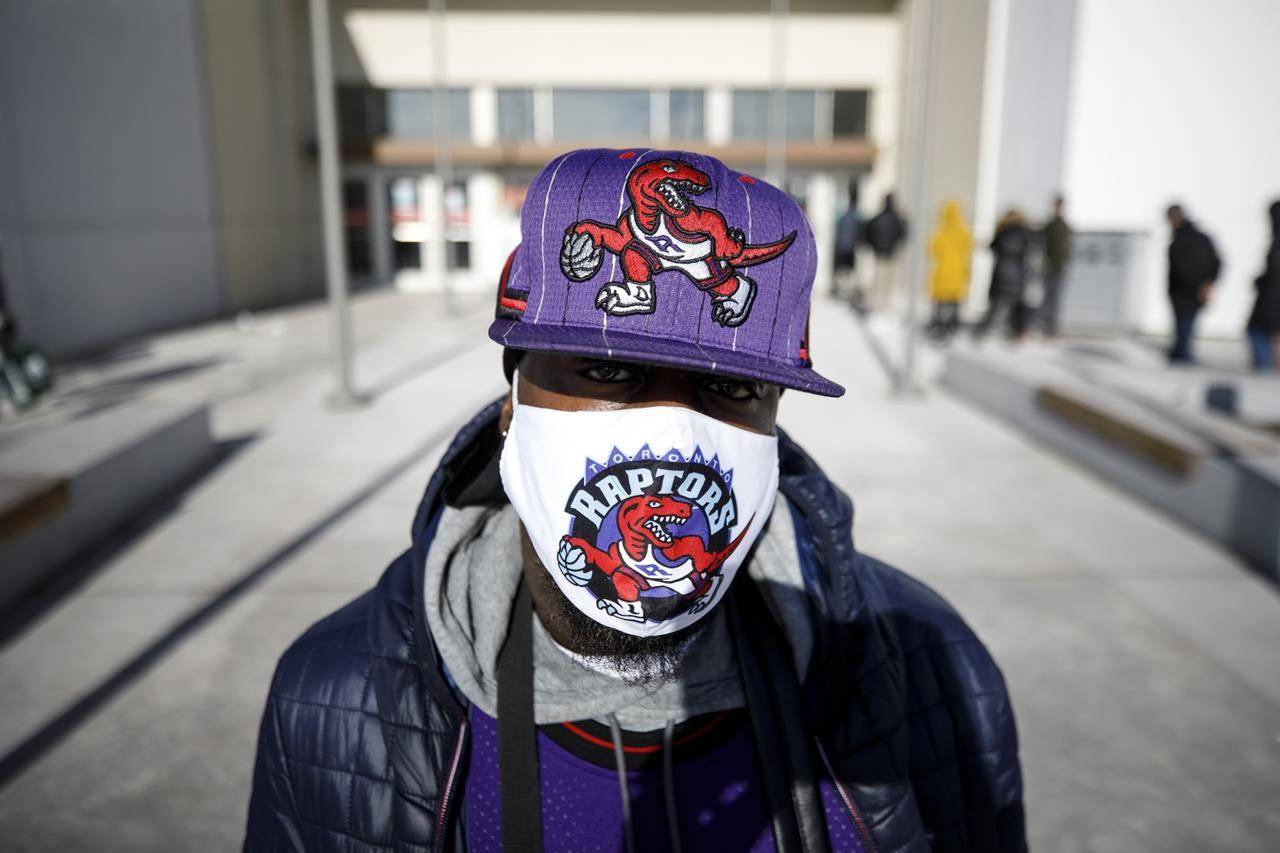 A shopper shows off his Toronto Raptors protective mask outside Vaughan Mills Shopping Centre in Vaughan, Ont., Sunday, Nov. 29, 2020. The Toronto Raptors say three members of the organization have tested positive for COVID-19. THE CANADIAN PRESS/ Cole Burston