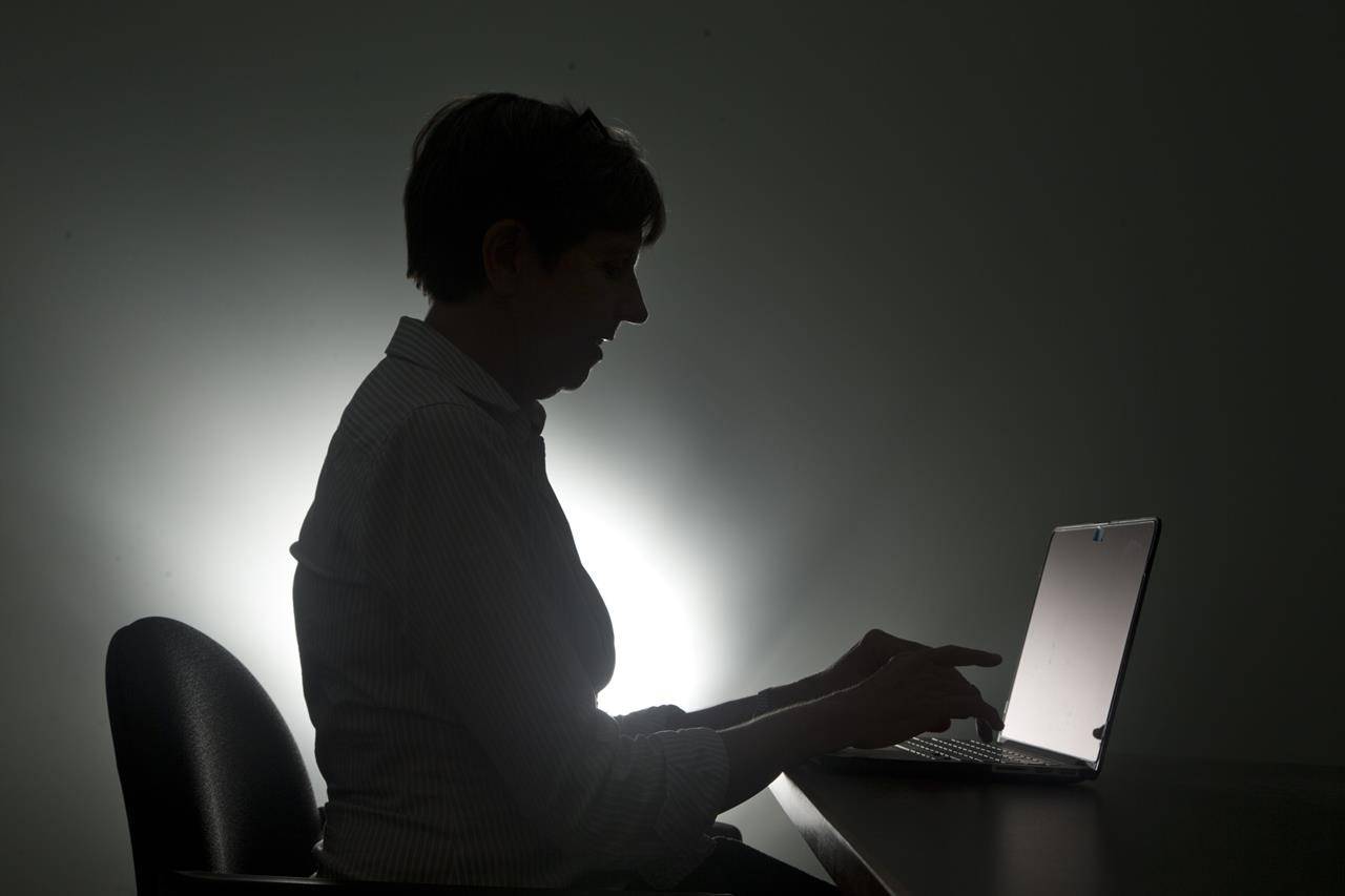 A woman types on her laptop in Miami in a Monday, Dec. 12, 2016, photo illustration. An investigation into a scourge of NetWalker ransomware attacks has led to the arrest of a Canadian man, the U.S. Department of Justice said on Wednesday. According to an indictment, police in Florida charged Sebastien Vachon-Desjardins of Gatineau, Que., with illegally obtaining more than $27.6 million. THE CANADIAN PRESS/AP/Wilfredo Lee
