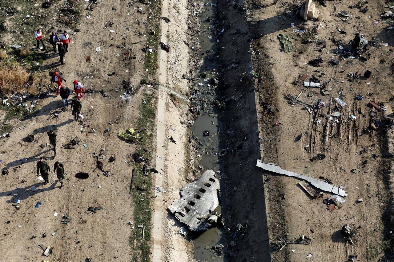 In this Jan. 8, 2020 file photo, rescue workers search the scene where a Ukrainian plane crashed in Shahedshahr, southwest of Tehran, Iran. Iranian investigators blamed a misaligned missile battery and miscommunication between soldiers and their commanders for the Revolutionary Guard shooting down the Ukrainian jetliner in January, killing 176 people. (AP Photo/Ebrahim Noroozi, File)