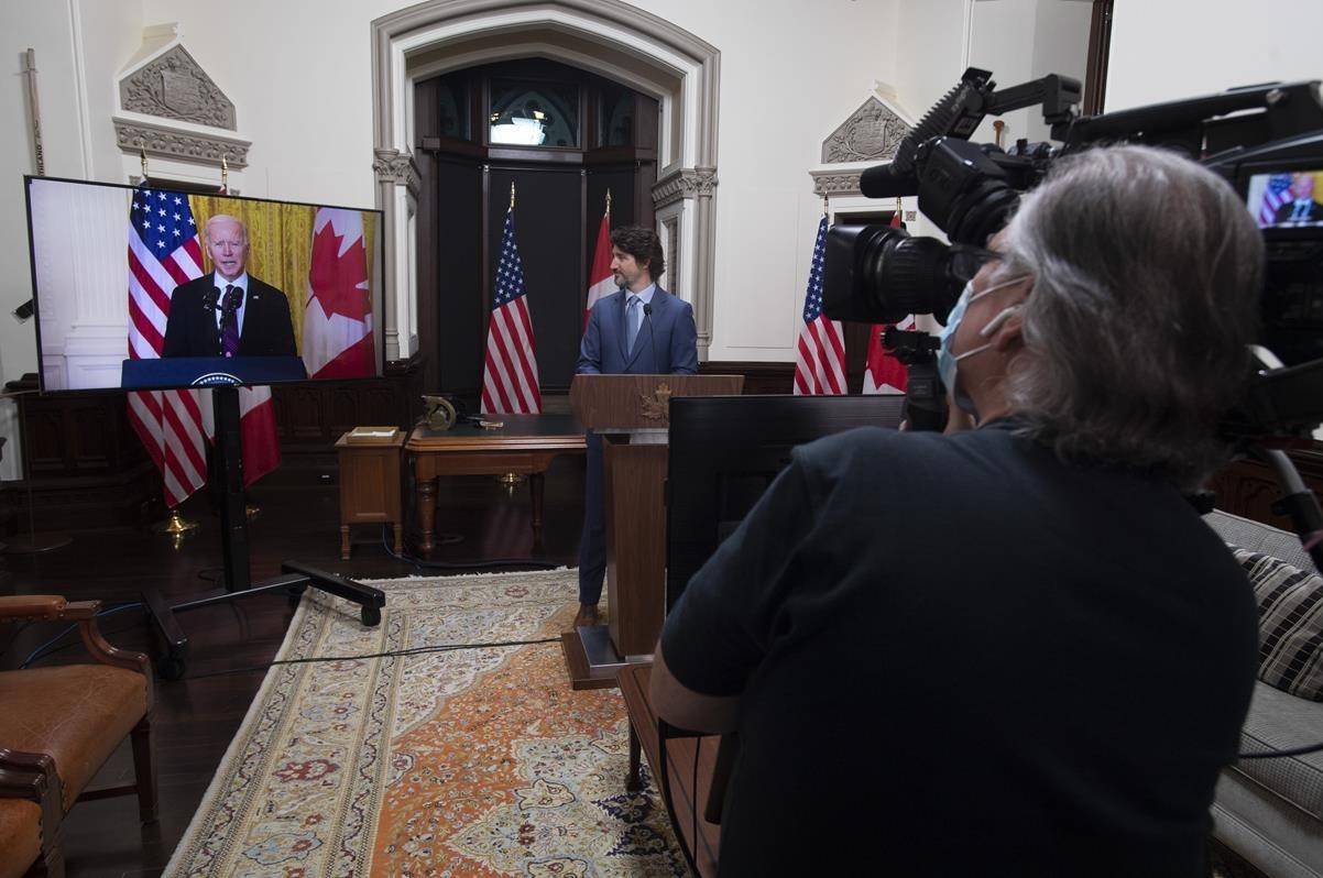 A cameraman records as Canadian Prime Minister Justin Trudeau and United States President Joe Biden participate in a virtual joint statement in Ottawa on February 23, 2021. THE CANADIAN PRESS/Adrian Wyld