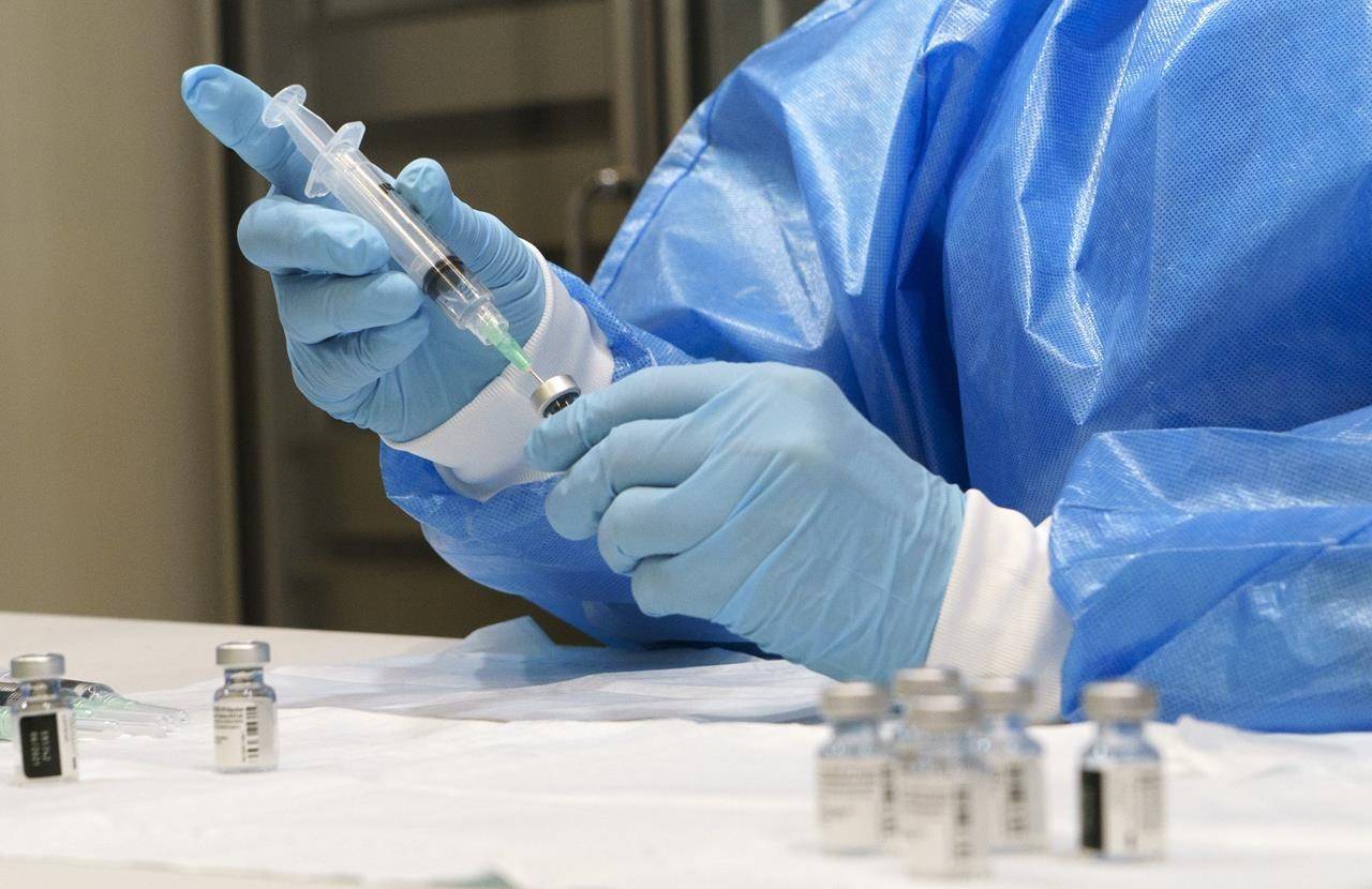 A syringe is prepared with COVID-19 vaccine at a vaccination clinic in Montreal on Monday, March 15, 2021. THE CANADIAN PRESS/Paul Chiasson