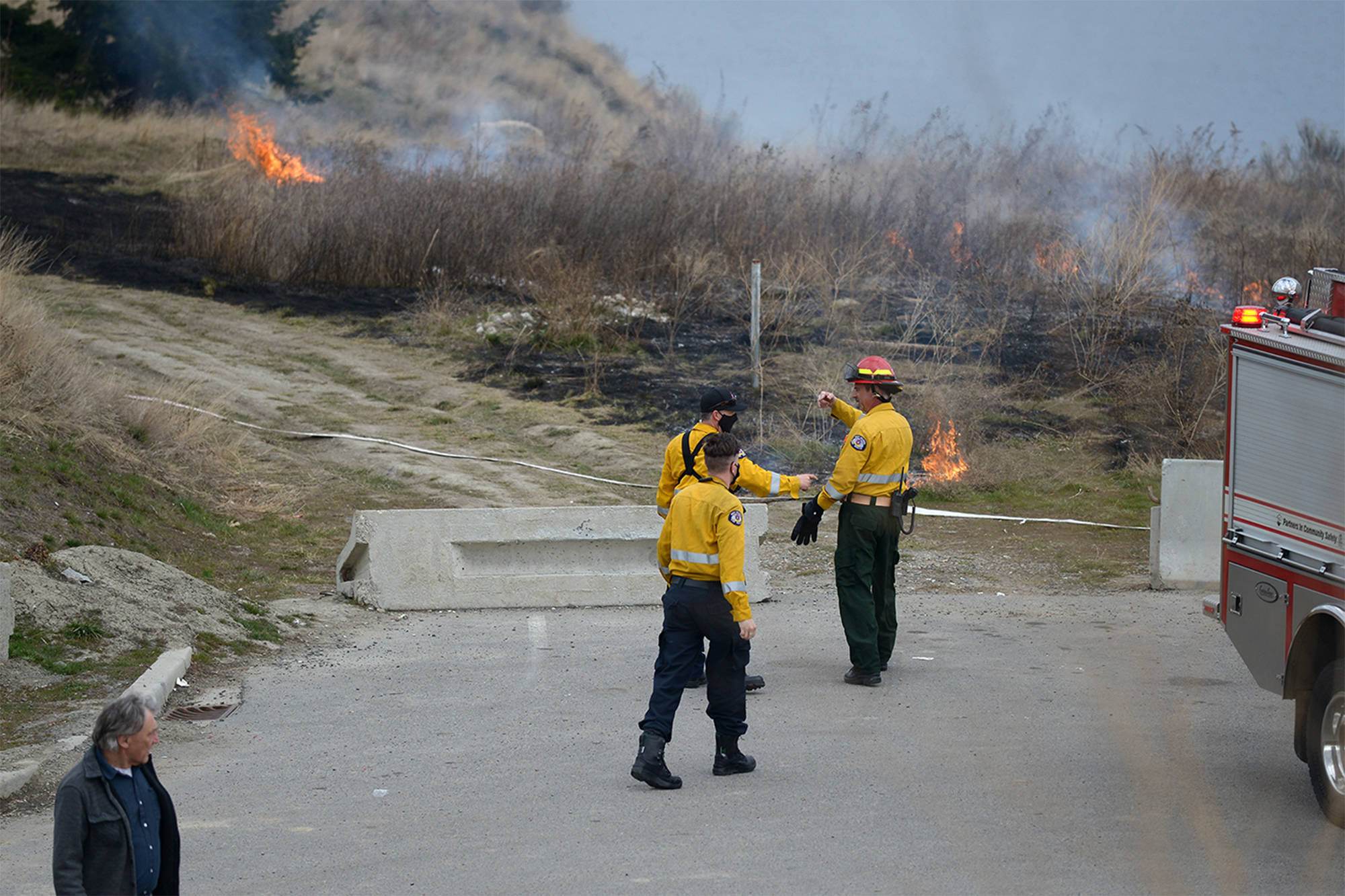 West Kelowna fire crews snuffed out patches of flame that ignited on the side of Highway 97 near the west side of William R. Bennett Bridge Saturday, March 20, 2021. (Phil McLachlan - Capital News)