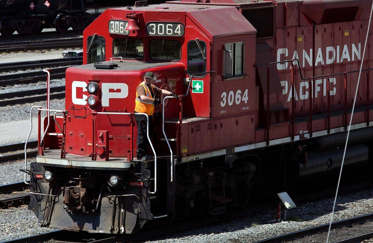 A Canadian Pacific Railway employee walks along the side of a locomotive in a marshalling yard in Calgary on May 16, 2012. THE CANADIAN PRESS/Jeff McIntosh