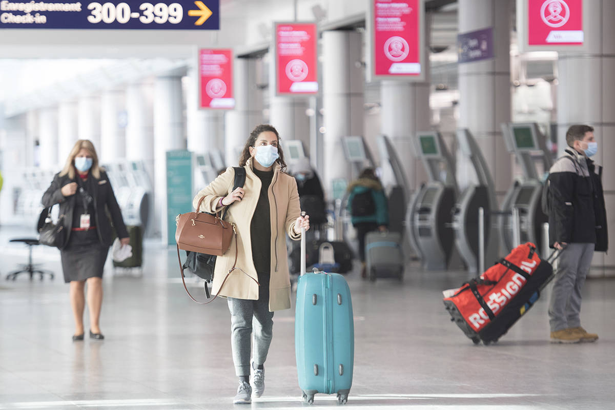 Passengers make their way through Montreal–Trudeau International Airport in Montreal, Saturday, December 19, 2020, as the COVID-19 pandemic continues in Canada and around the world. THE CANADIAN PRESS/Graham Hughes