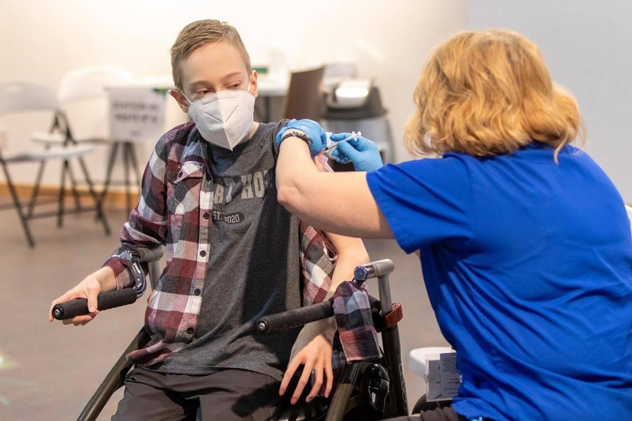Riley Oldford, 16, suffers from cerebral palsy. He was the first youth in the Northwest Territories to get a COVID-19 vaccine. Here he receives the needle from nurse practitioner Janie Neudorf in Yellowknife on Thursday May 6, 2021. THE CANADIAN PRESS/Bill Braden