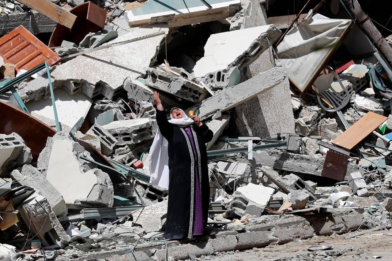 A woman reacts while standing near the rubble of a building that was destroyed by an Israeli airstrike on Saturday that housed The Associated Press, broadcaster Al-Jazeera and other media outlets, in Gaza City, Sunday, May 16, 2021. (AP Photo/Adel Hana)