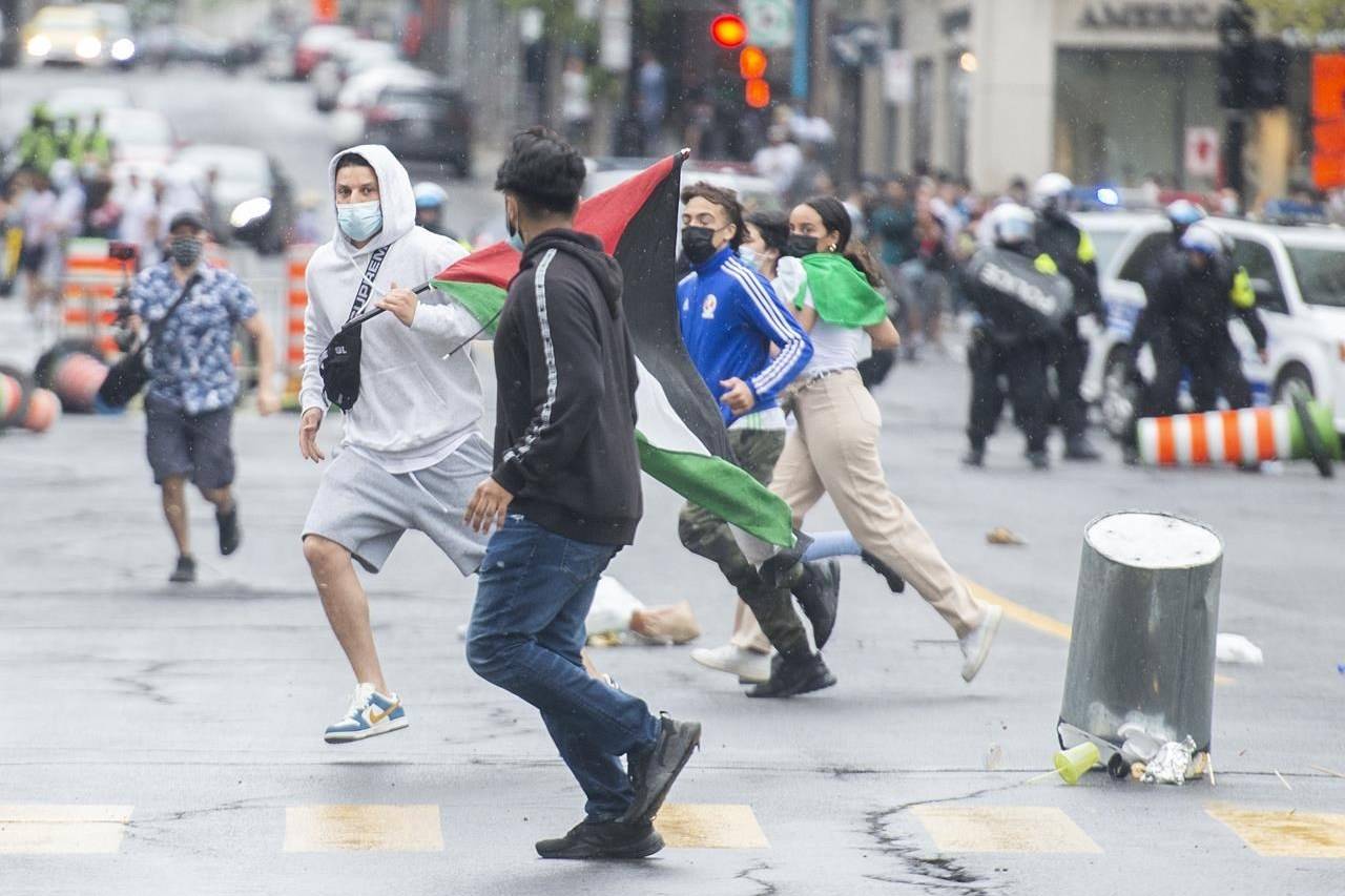 Pro-Palestinian protesters run from police following a demonstration in Montreal, Sunday, May 16, 2021. THE CANADIAN PRESS/Graham Hughes