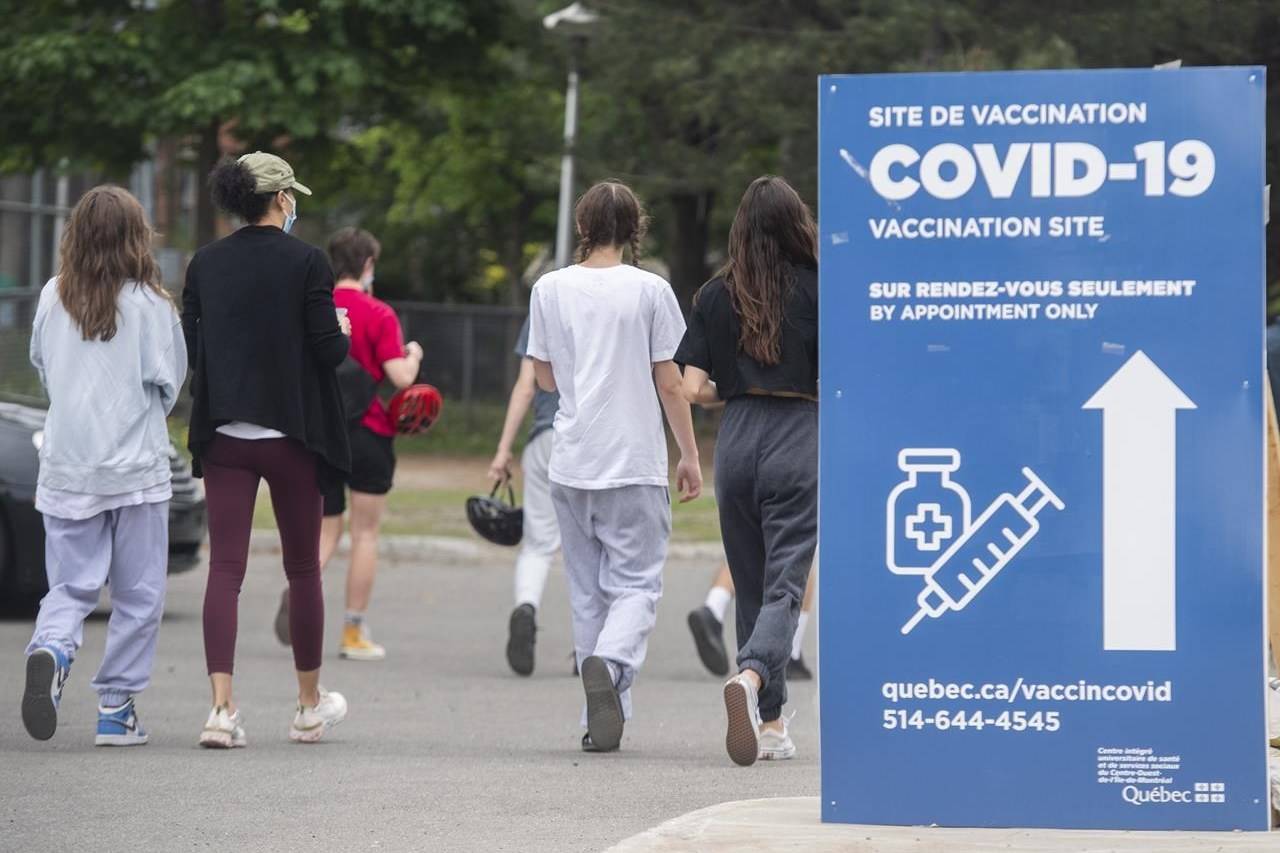 Young people walk into a COVID-19 vaccination site in Montreal, Saturday, May 22, 2021. More than 50 per cent of Canadians have now received at least one dose of vaccine. THE CANADIAN PRESS/Graham Hughes
