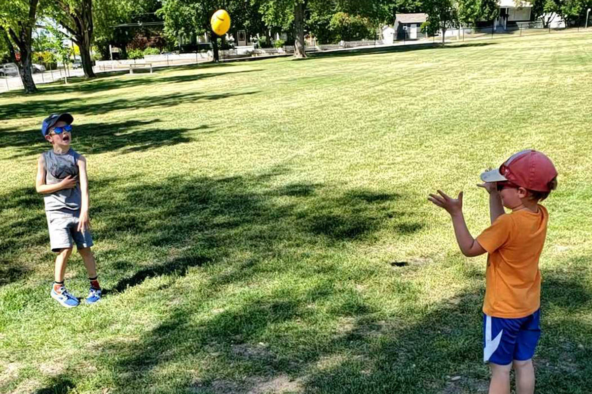 Ethan Powell, six, left, tosses a mini football to little brother Declan, four, at Vernon’s Lakeview Park. The mini football is part of the newly stocked Unplug and Play Box, courtesy of the North Okanagan Optimist Club, which is open for public use again after being closed all of 2020 due to COVID. (Roger Knox - Morning Star)