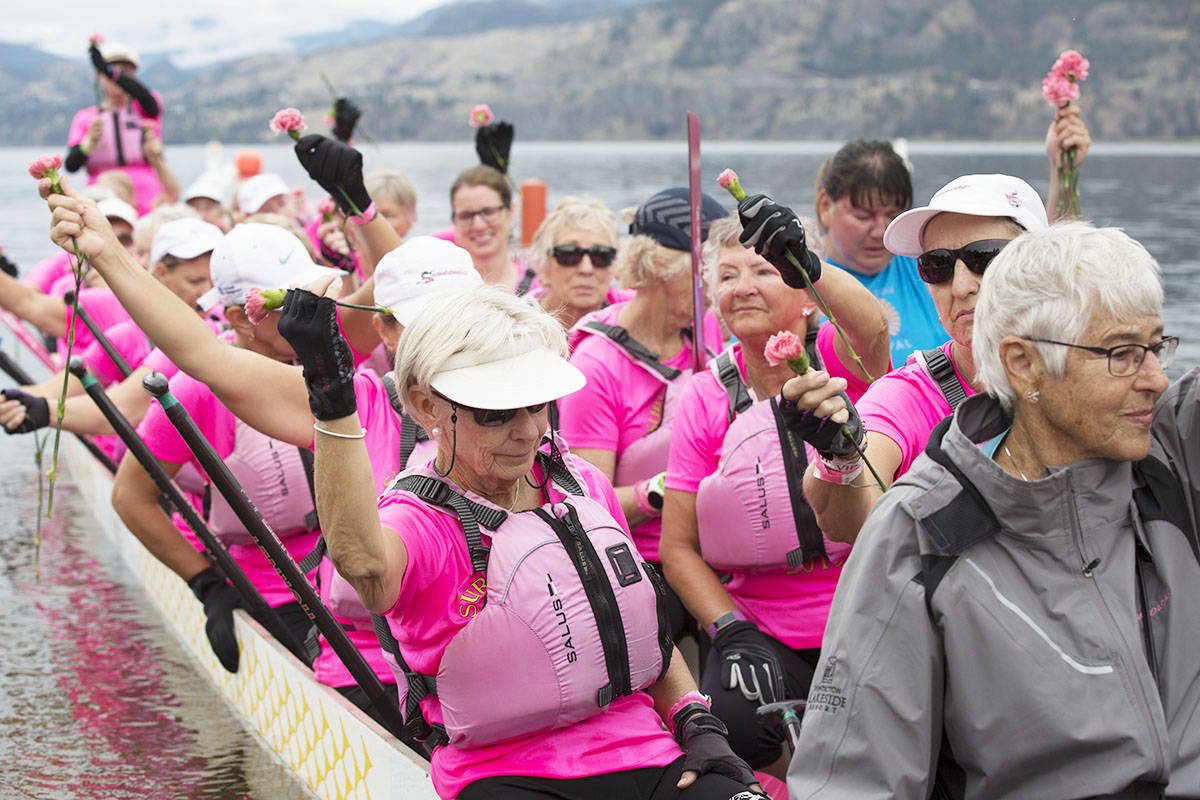 Survivorship paddlers hold up pink carnations to honour women fighting breast cancer and those who have lost their lives on the last day of the Penticton Dragonboat Festival in 2019. Many Survivorship paddlers have become volunteers of Tomorrow’s Hope. (Western News file photo)