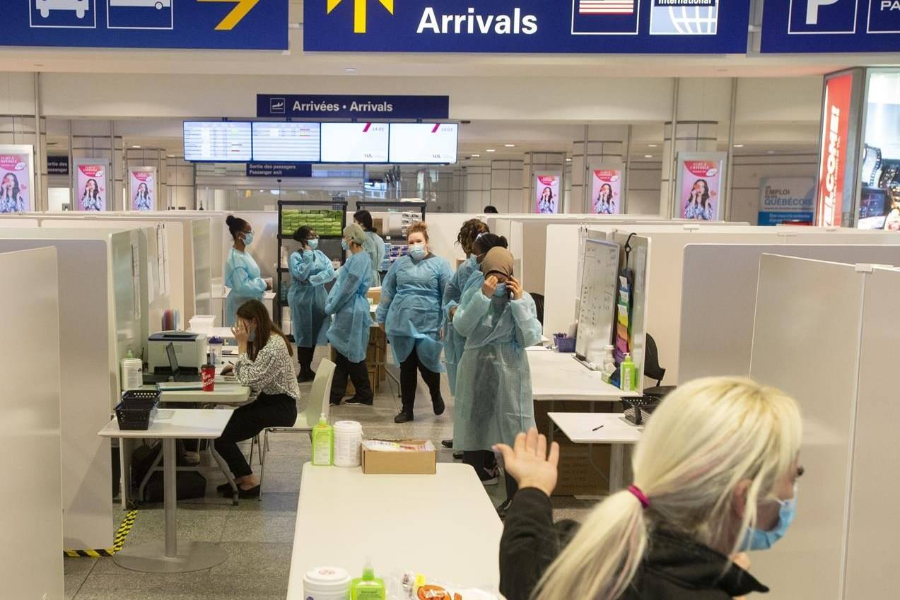 Health-care workers wait for airline passengers at a COVID-19 testing centre at Trudeau Airport in Montreal, Friday, Feb. 19, 2021. THE CANADIAN PRESS/Ryan Remiorz