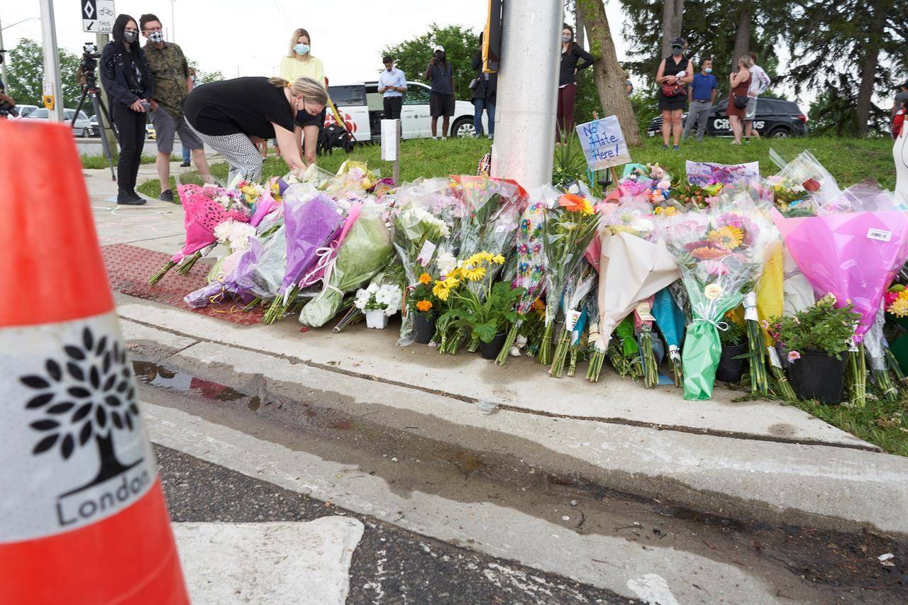 Mourners place flowers at the scene of a hate-motivated vehicle attack in London, Ont. on Tuesday, June 8, 2021, which left four members of a family dead and their nine-year-old son in hospital. THE CANADIAN PRESS/ Geoff Robins