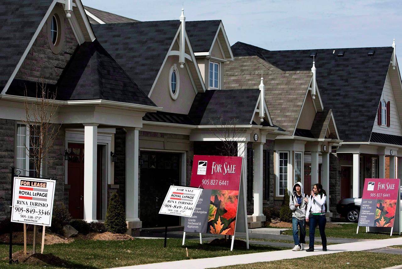 People walk past new homes for sale in Oakville, Ont., on Tuesday, April 14, 2009. THE CANADIAN PRESS/Nathan Denette