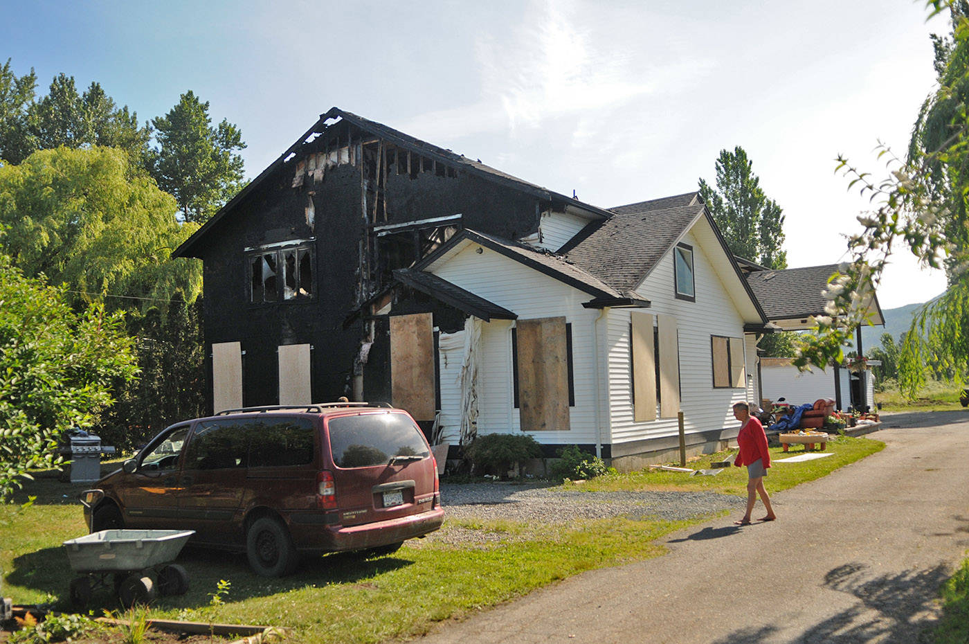 A tenant walks in front of her home on Boundary Road on Friday, June 18, 2021 after it was destroyed by fire the night before in Chilliwack. (Jenna Hauck/ Chilliwack Progress)
