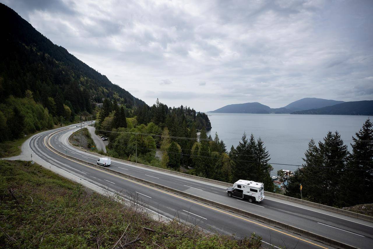 A motorist with a truck camper travels on the Sea-to-Sky highway between Horseshoe Bay and Lions Bay, B.C., on Friday, April 23, 2021. A new report from Canada’s parliamentary budget officer says the speed at which change needs to happen for how people drive and heat buildings will make it tough for the Liberal government to achieve its latest climate goal. THE CANADIAN PRESS/Darryl Dyck