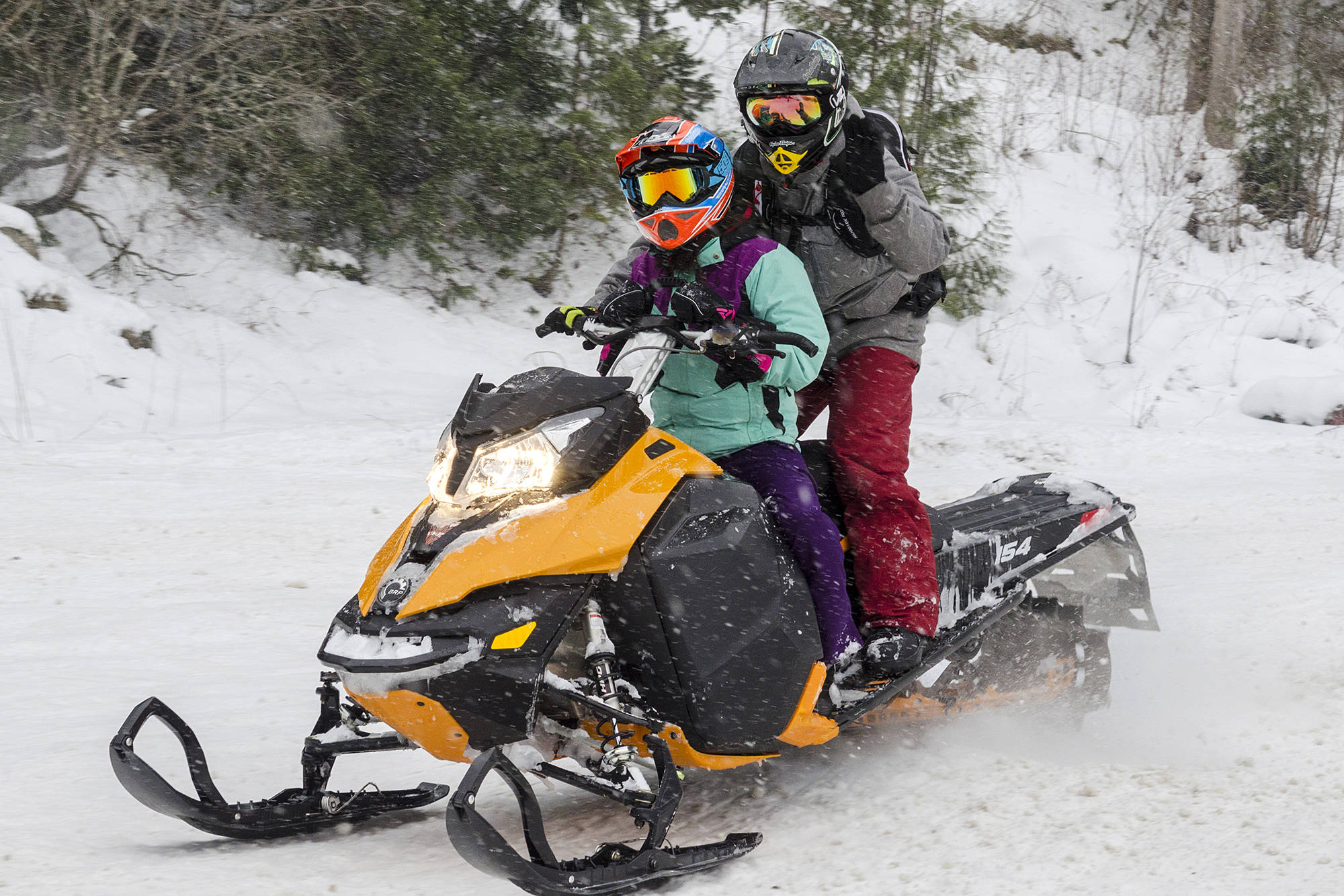 A sledder drives while their passenger waves during a previous snowmobile season in Sicamous. (File photo)