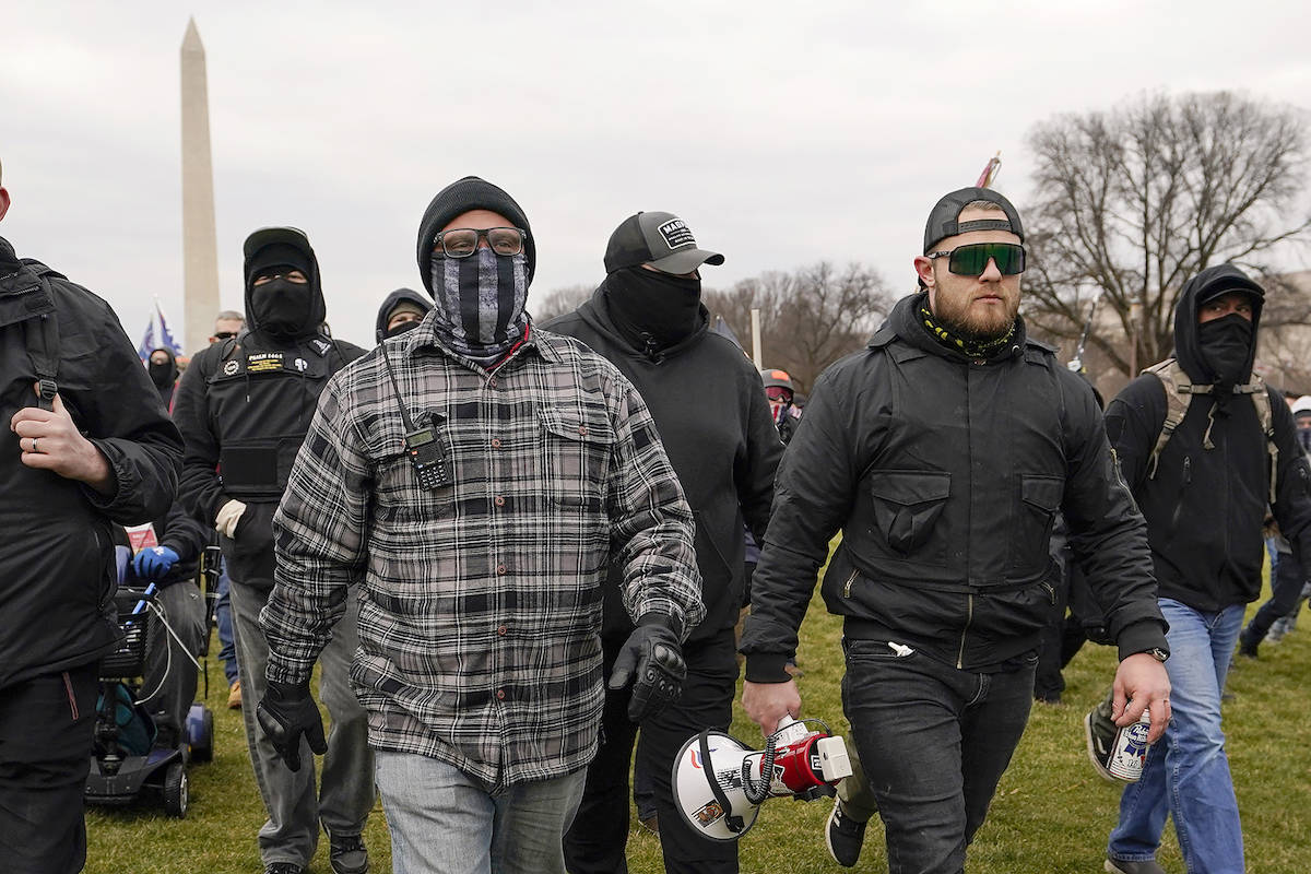 In this Jan. 6, 2021, photo, Proud Boy members Joseph Biggs, left, and Ethan Nordean, right with megaphone, walk toward the U.S. Capitol in Washington, in support of President Donald Trump. (AP Photo/Carolyn Kaster)