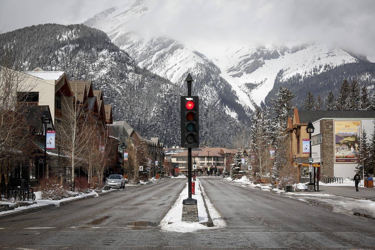 The empty streets of Banff are seen as Parks Canada is restricting vehicles in the national parks and national historic sites due to the COVID-19 pandemic, in Banff, Alta., Tuesday, March 24, 2020. Even as Alberta plans to drop nearly all COVID-19 restrictions on July 1st, local businesses and the Banff National Park’s tourism board say they’ll be sorely missing international tourists for a second peak summer season in a row. THE CANADIAN PRESS/Jeff McIntosh