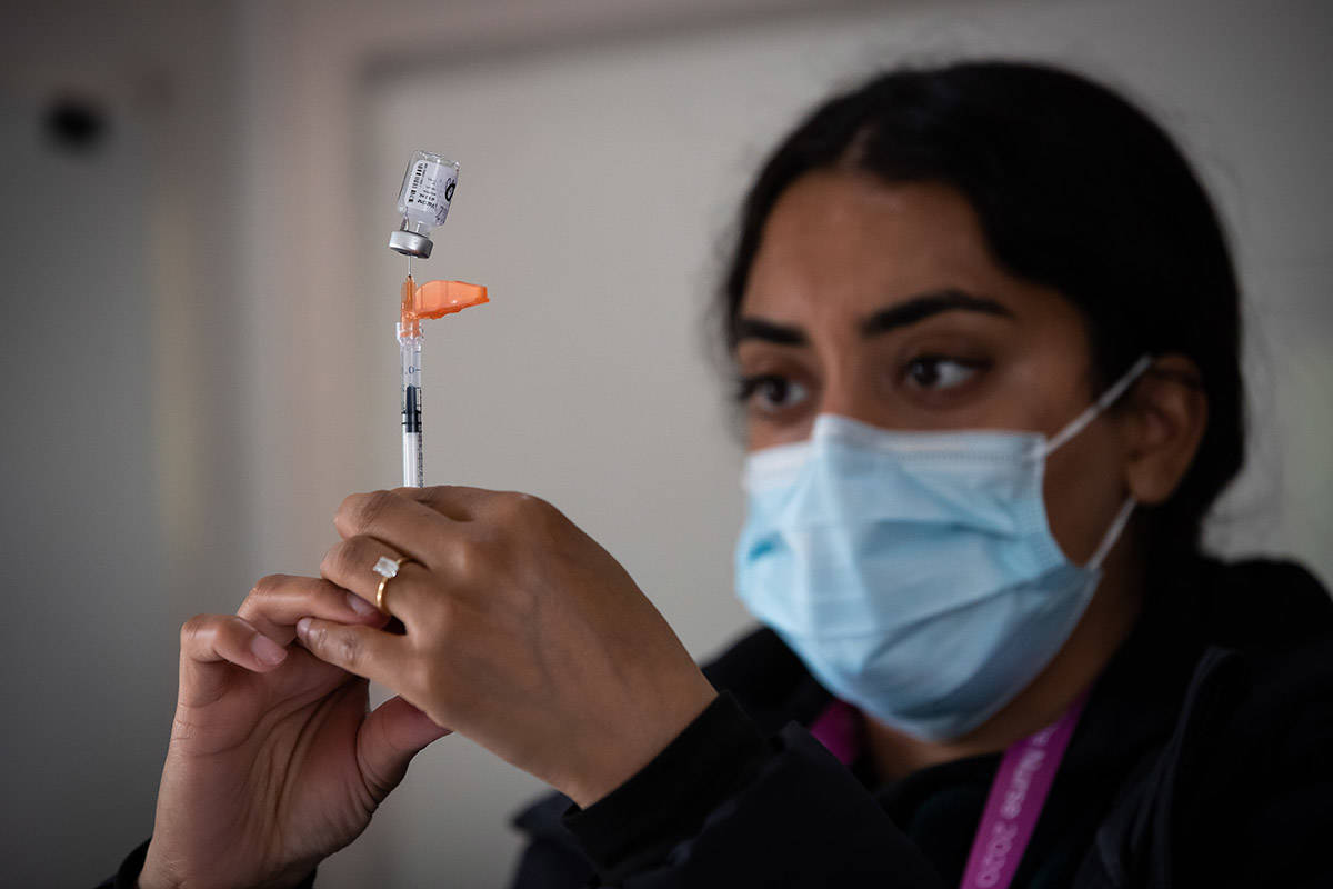 Fraser Health registered nurse Ramn Manan draws a dose of the Pfizer COVID-19 vaccine into a syringe at a walk-up vaccination clinic at Bear Creek Park, in Surrey, B.C., on Monday, May 17, 2021. THE CANADIAN PRESS/Darryl Dyck