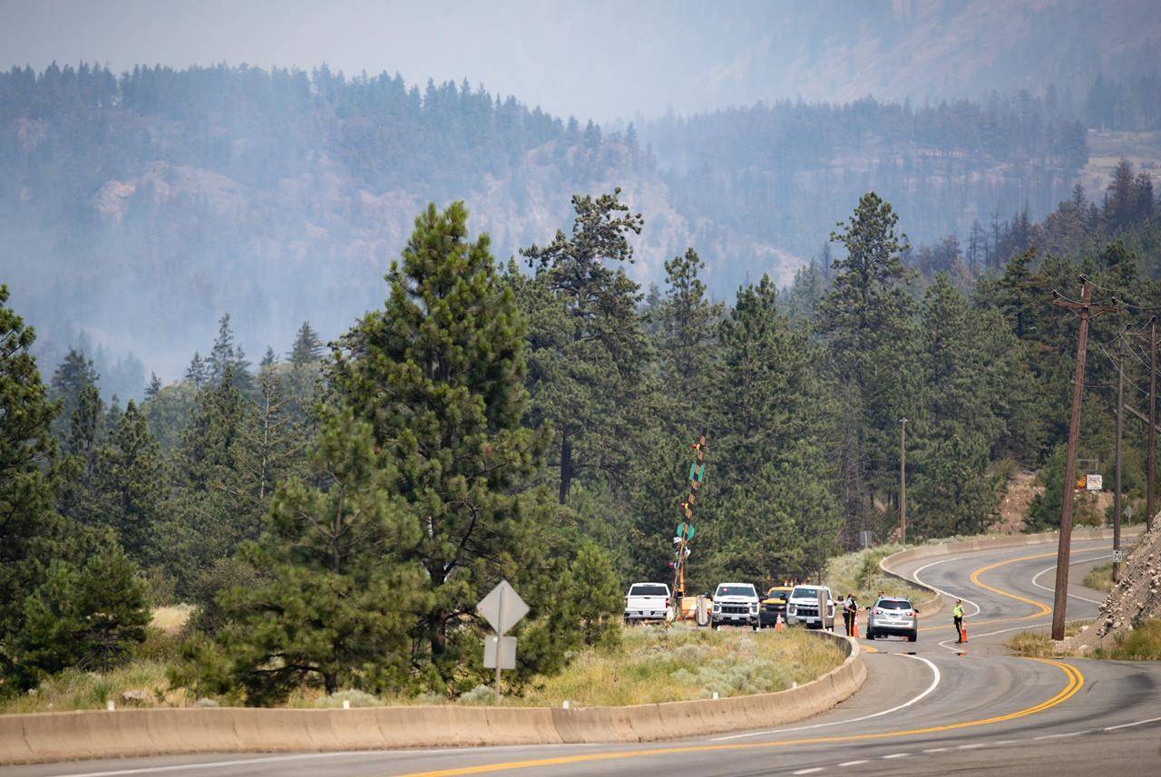 RCMP officers man a roadblock on the Trans-Canada Highway as wildfire burns in Lytton, B.C., Friday, July 2, 2021. The BC Wildfire Service says there has been minimal growth in fire that destroyed much of the village of Lytton, B.C., in the past day .THE CANADIAN PRESS/Darryl Dyck