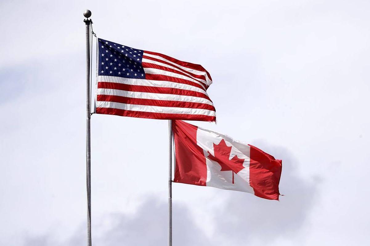 The U.S. and Canadian flags fly atop the Peace Arch at Peace Arch Historical State Park on the border with Canada in Blaine, Wash. THE CANADIAN PRESS/AP, Elaine Thompson