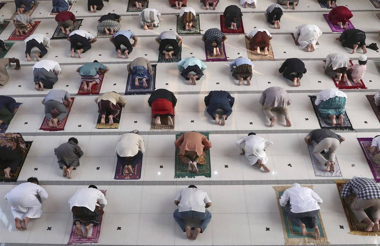 Muslims pray spaced apart as a precaution against the coronavirus outbreak during an Eid al-Adha prayer at Zona Madina mosque in Bogor, Indonesia, Tuesday, July 20, 2021. Muslims across Indonesia marked a grim Eid al-Adha festival for a second year Tuesday as the country struggles to cope with a devastating new wave of coronavirus cases and the government has banned large gatherings and toughened travel restrictions. (AP Photo/Tatan Syuflana)