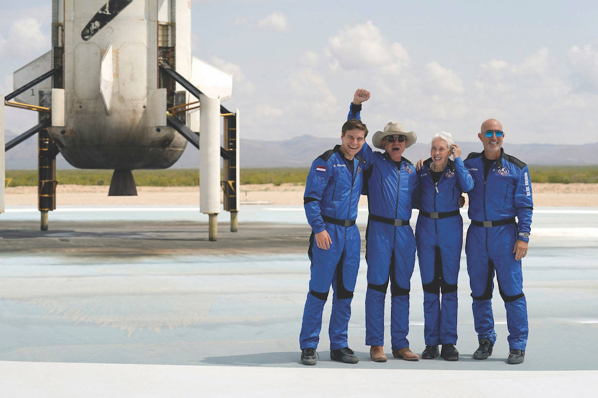 Oliver Daemen, from left, Jeff Bezos, founder of Amazon and space tourism company Blue Origin, Wally Funk and Bezos' brother Mark pose for photos in front of the Blue Origin New Shepard rocket, left rear, after their launch from the spaceport near Van Horn, Texas, Tuesday, July 20, 2021. (AP Photo/Tony Gutierrez)