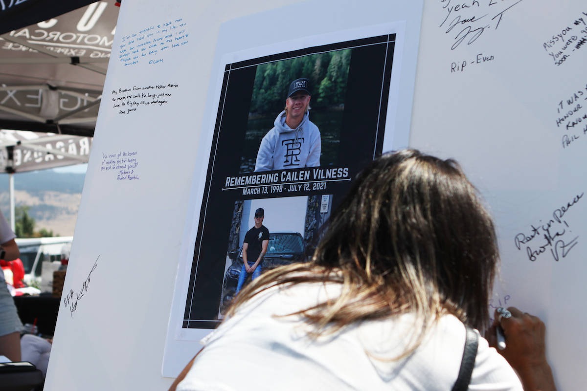 A guest signs a message board for Cailen Vilness at a memorial meet and fundraiser for the 23-year-old, which was hosted at Kelowna’s August Luxury Motorcars on July 24. (Aaron Hemens/Capital News)